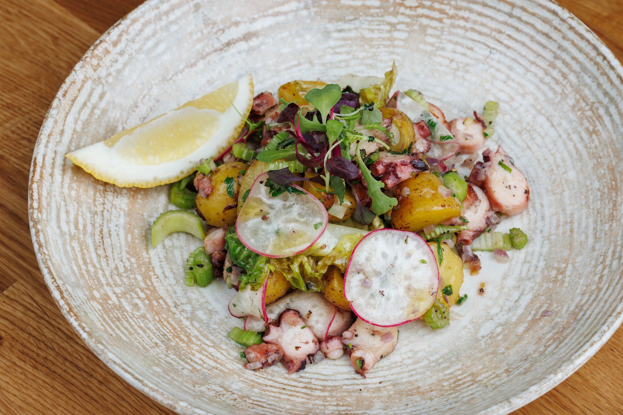Insalata di mare con patate, sedano, olive ed erbe aromatiche