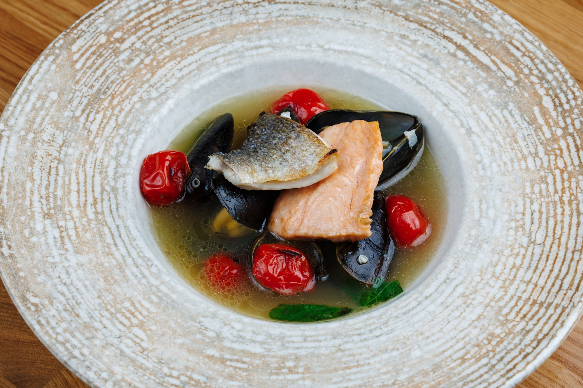 Zuppa di pesce leggera con salmone, orata, cozze e pomodorini italiani