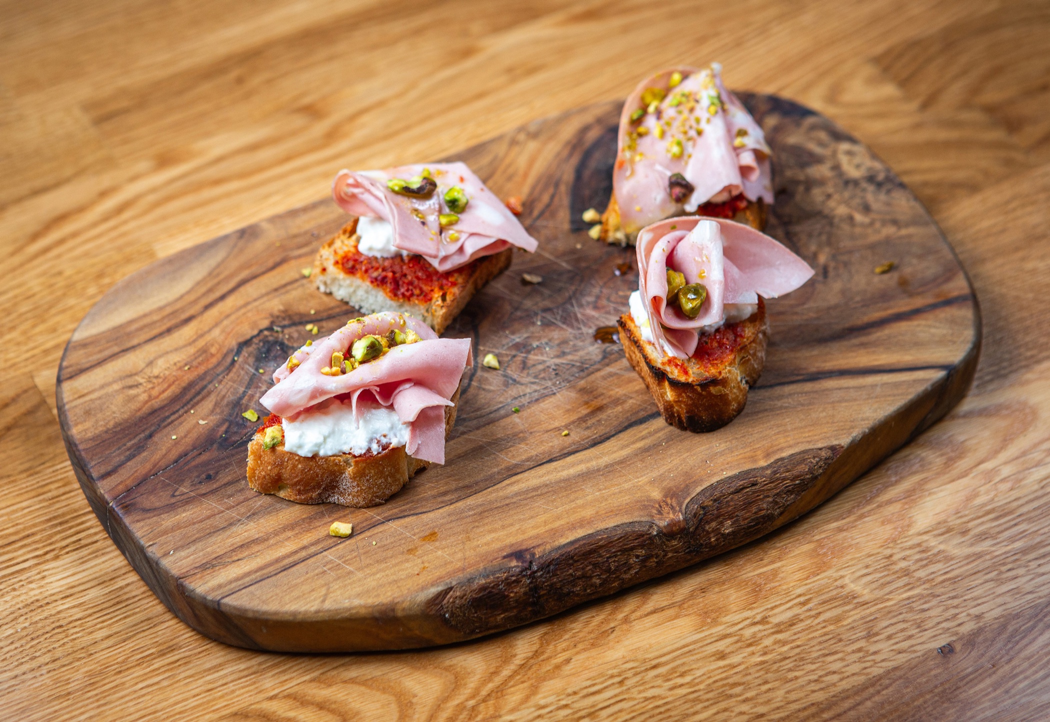 Bruschetta con mortadella, stracciatella cremosa e pomodorini italiani al forno